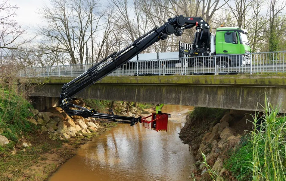 Mercedes-Benz Arocs mit HIAB-Ladekran hebt eine Last über eine Brücke